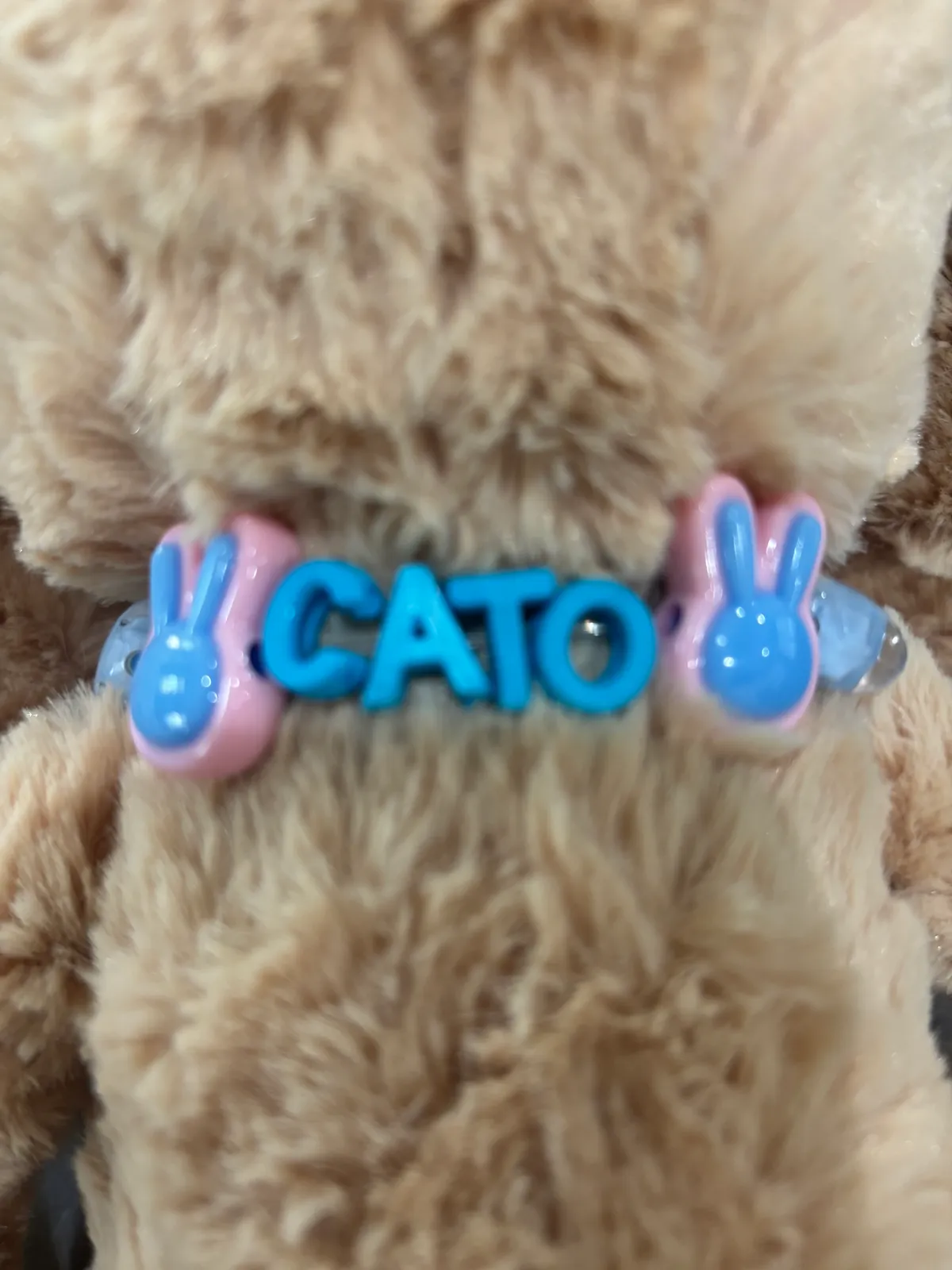 A plush bunny wearing a custom beaded name collar made at the party workshop
