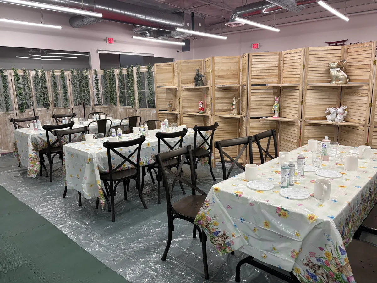 The workshop area set for a party — craft tables and shelves of plush bunnies