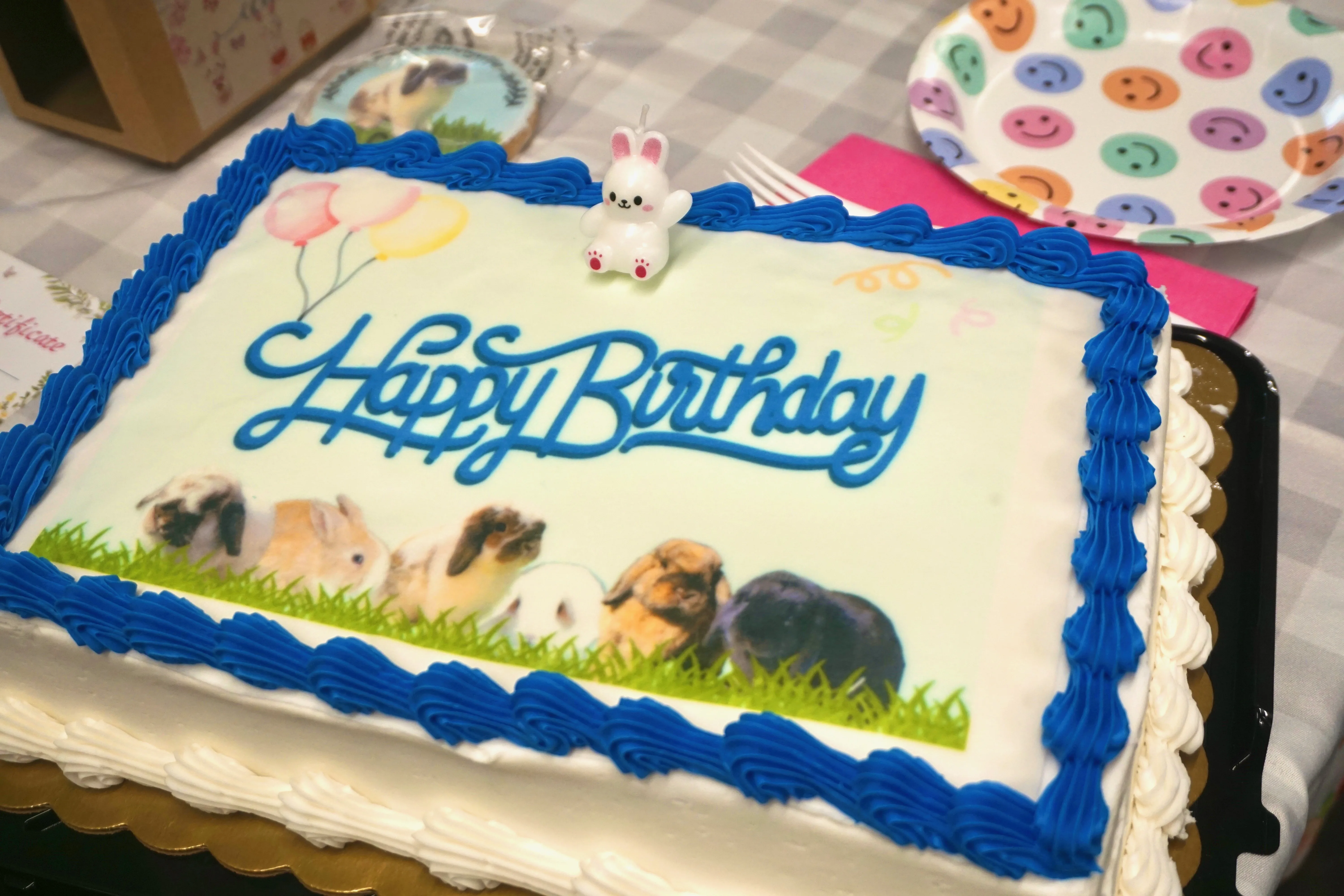 A birthday cake with bunnies in the frosting design